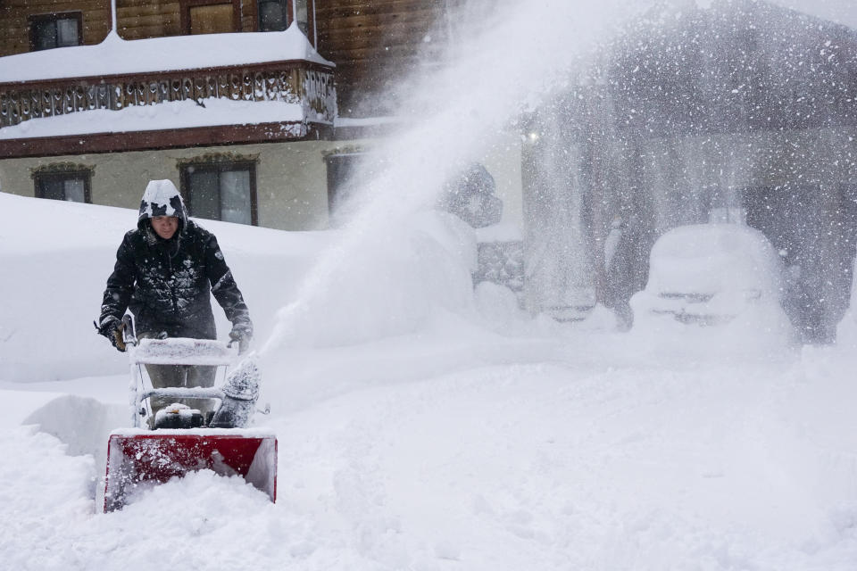 Snow is cleared from a sidewalk during a storm, Sunday, March 3, 2024, in Truckee, Calif. (AP Photo/Brooke Hess-Homeier)