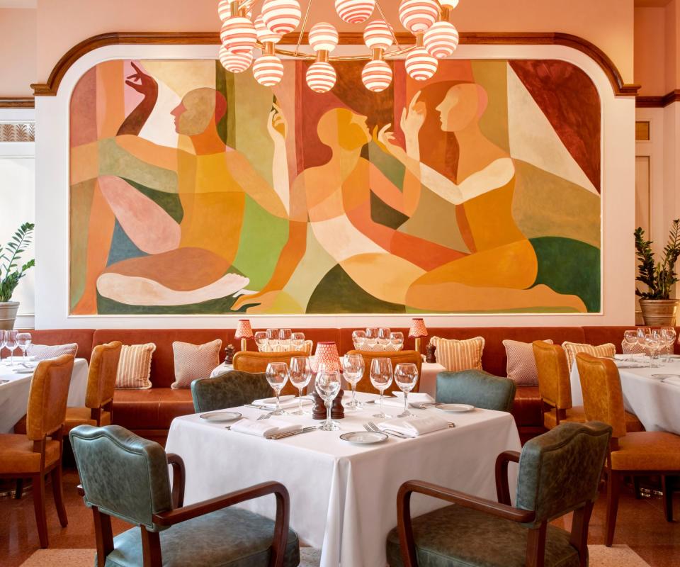 Restaurant with huge mural behind tables