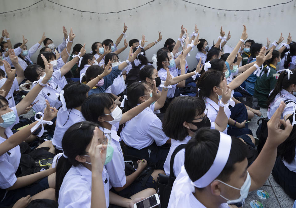 Pro-democracy students raise a three-fingers, symbol of resistance salute during a protest rally in front of Education Ministry in Bangkok, Thailand, Wednesday, Aug. 19, 2020. Student protesters have stepped up pressure on the government with three core demands: holding new elections, amending the constitution and ending the intimidation of critics of the government. (AP Photo/Sakchai Lalit)
