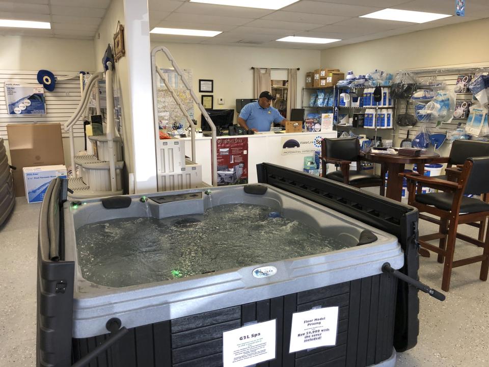 In this March 27, 2020 photo, Aric Strickland works at his business Leisure Life Pools, Spas & Billiards in Lugoff, SC. Strickland said his business should be considered essential if South Carolina's governor gives a stay at home order. (AP Photo/Jeffrey Collins)
