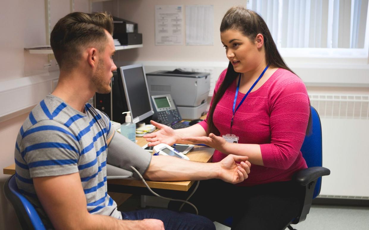 A young man in a doctor's surgery - iStockphoto 