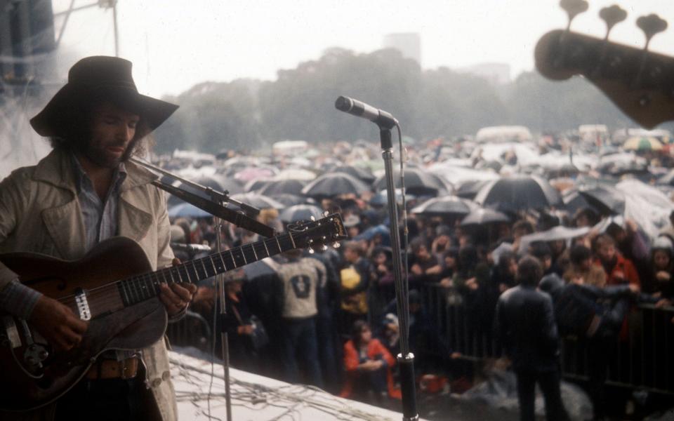 Chapman entertains a rain-soaked festival in the late 1960s - Alain Dister/Dalle/Retna Pictures/Dalle/Avalon