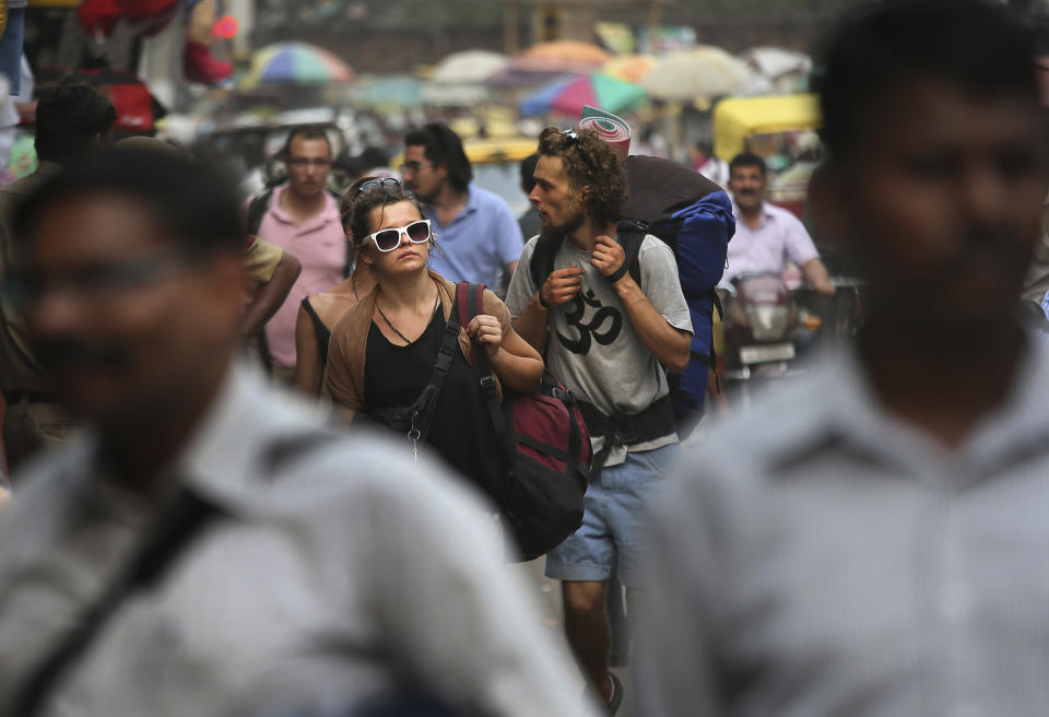 In this Tuesday, April 2, 2013 photo, foreign tourists look for a hotel near the railway station in New Delhi, India. Violence against women, and the huge publicity generated by recent attacks here, is threatening India's $17.7 billion tourism industry. A new study shows tourism has plunged, especially among women, since a 23-year-old Indian student was raped on a New Delhi bus and later died from her injuries, a case that garnered worldwide publicity. (AP Photo /Manish Swarup)