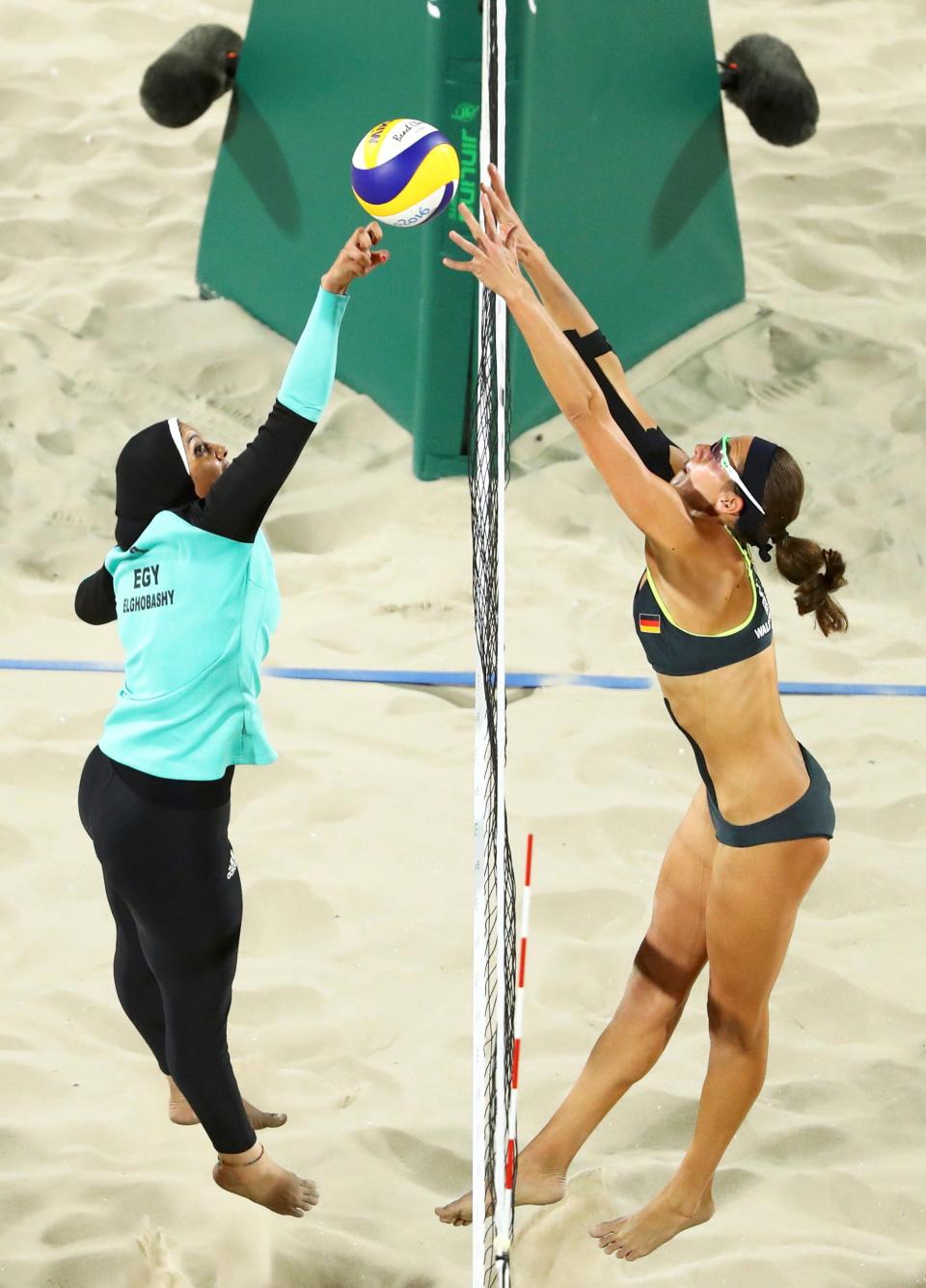 Women's volleyball at the 2016 Rio Olympics. The player on the left wears a hijab, and the player on the right wears a bikini.