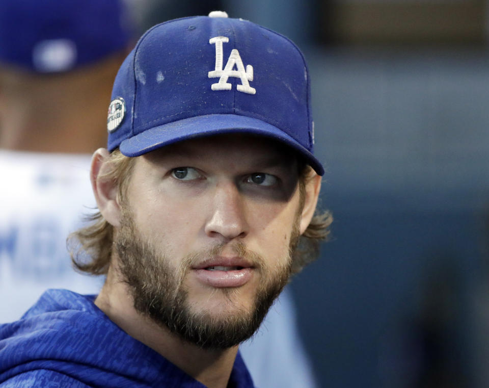 FILE - In this Oct. 16, 2018 file photo, Los Angeles Dodgers pitcher Clayton Kershaw watches before Game 4 of the National League Championship Series baseball game against the Milwaukee Brewers in Los Angeles. The Dodgers and three-time Cy Young Award winner Kershaw reached an agreement on a contract extension Friday, Nov. 2, 2018, that will keep the seven-time All-Star with the club through 2021. (AP Photo/Jae C. Hong, File)