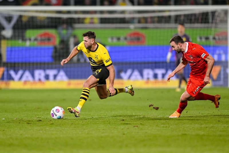 Dortmund's Niclas Fuellkrug (L) and Heidenheim's Benedikt Gimber battle for the ball during the German Bundesliga soccer match between 1. FC Heidenheim and Borussia Dortmund at Voith-Arena. Harry Langer/dpa