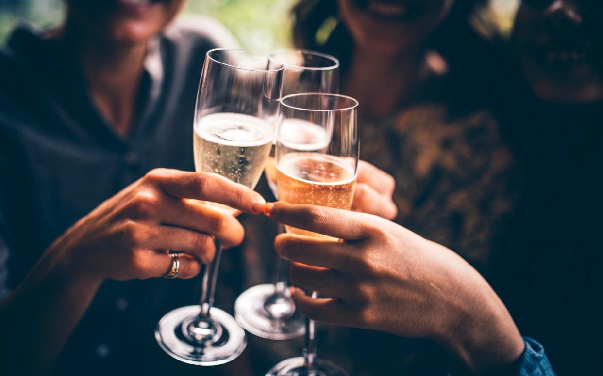 Three female friends celebrating with champagne - AzmanL