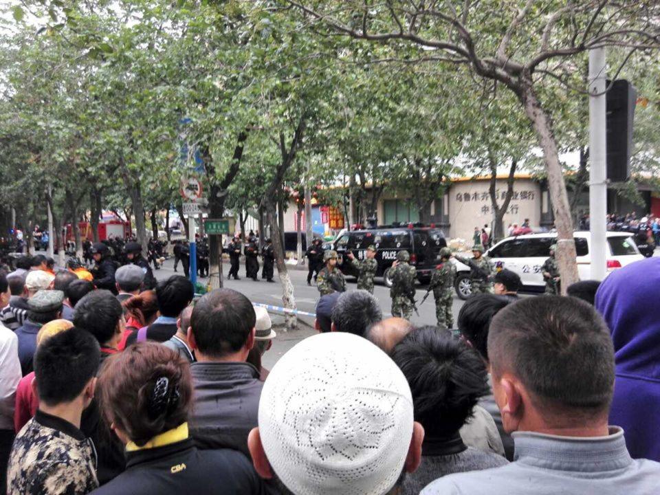 People look on at a street cordoned off by police after a blast in Urumqi, Xinjiang Uyghur Autonomous Region May 22, 2014. (REUTERS/CNSphoto)