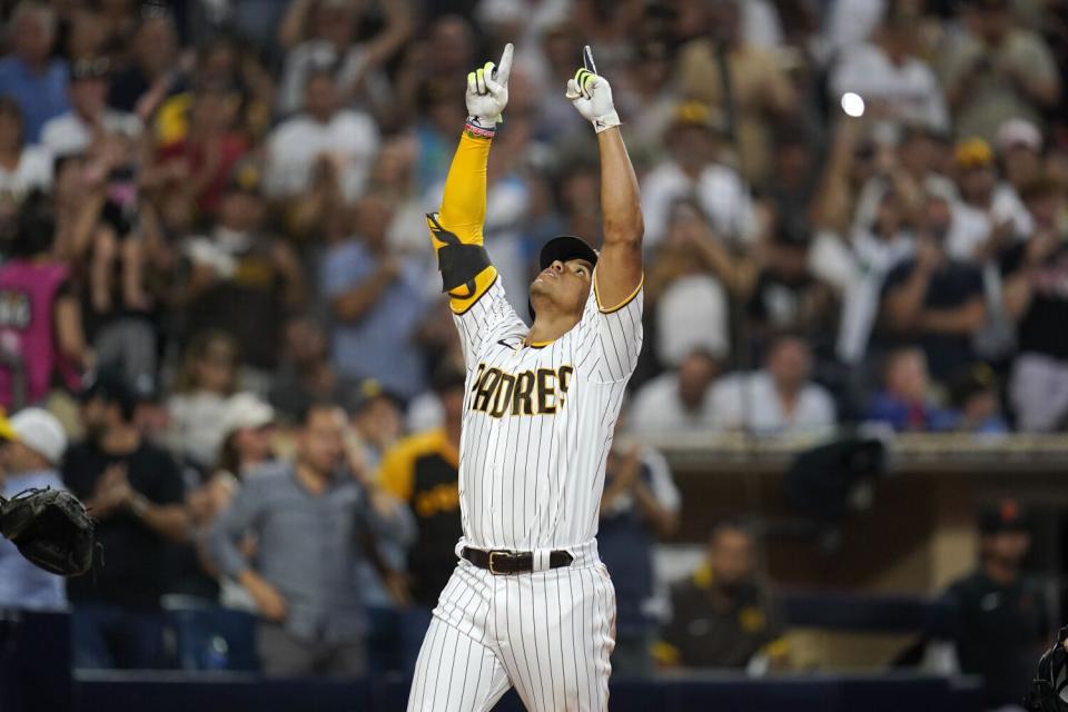 The San Diego Padres' Juan Soto points skyward after hitting a home run.