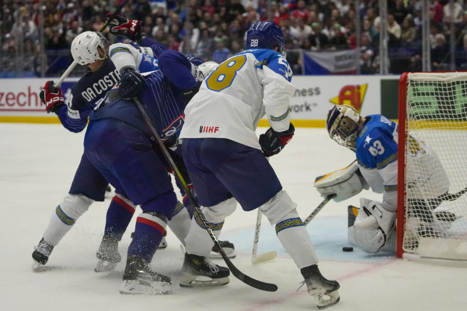 Kazakhstan's goalkeeper Andrey Shutov, rught, makes a save in front of France's Stephane da Costa, left, during the preliminary round match between France and Kazakhstan at the Ice Hockey World Championships in Ostrava, Czech Republic, Saturday, May 11, 2024. (AP Photo/Darko Vojinovic)