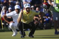 Webb Simpson, front, and Tony Finau, back, line up their putts on the 18th green during the final round of the Waste Management Phoenix Open PGA Tour golf event Sunday, Feb. 2, 2020, in Scottsdale, Ariz. (AP Photo/Ross D. Franklin)