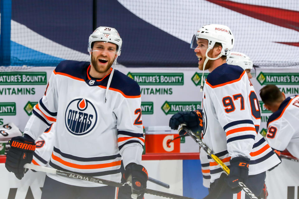 WINNIPEG, MB - APRIL 26: Leon Draisaitl #29 and Connor McDavid #97 of the Edmonton Oilers share a laugh during the pre-game warm up prior to NHL action against the Winnipeg Jets at the Bell MTS Place on April 26, 2021 in Winnipeg, Manitoba, Canada. (Photo by Jonathan Kozub/NHLI via Getty Images)