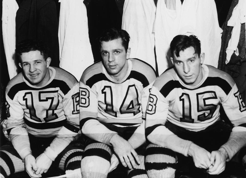 <p>Canadian professional hockey players and childhood friends (left to right) Bobby Bauer (1915 – 1964), Woody Dumart (1916 – 2001), and Milt Schmidt of the Boston Bruins’ legendary ‘Kraut Line’ sit on a bench in the locker room and pose for a photograph before their last professional game before joining the Royal Canadian Air Force, 1942. (Photo by Bruce Bennett Studios/Getty Images) </p>