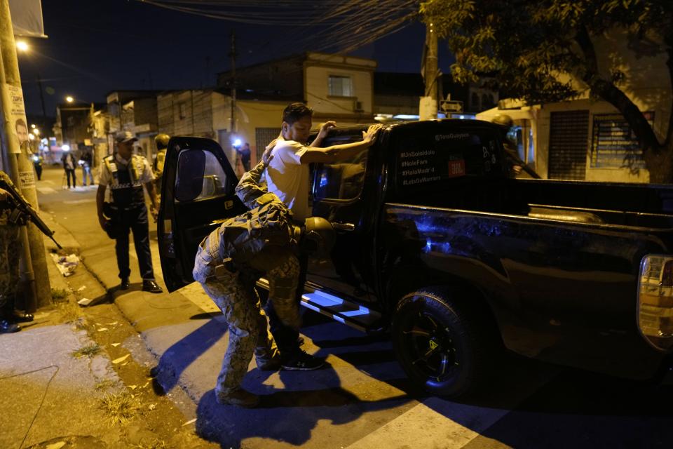 Soldiers search a car's driver at a security check placed by the army in Guayaquil, Ecuador, Wednesday, Aug. 16. Ecuador goes to the polls Sunday to elect a president. (AP Photo/Martin Mejia)