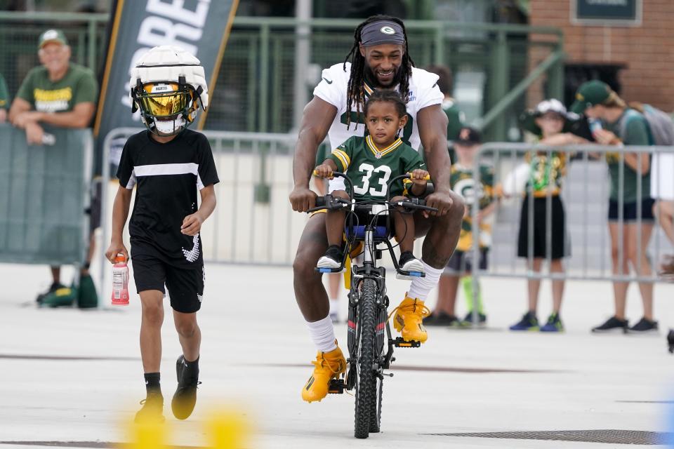 Green Bay Packers' Aaron Jones rides a bike to the NFL football team's practice field Wednesday, July 27, 2022, in Green Bay, Wis. (AP Photo/Morry Gash)