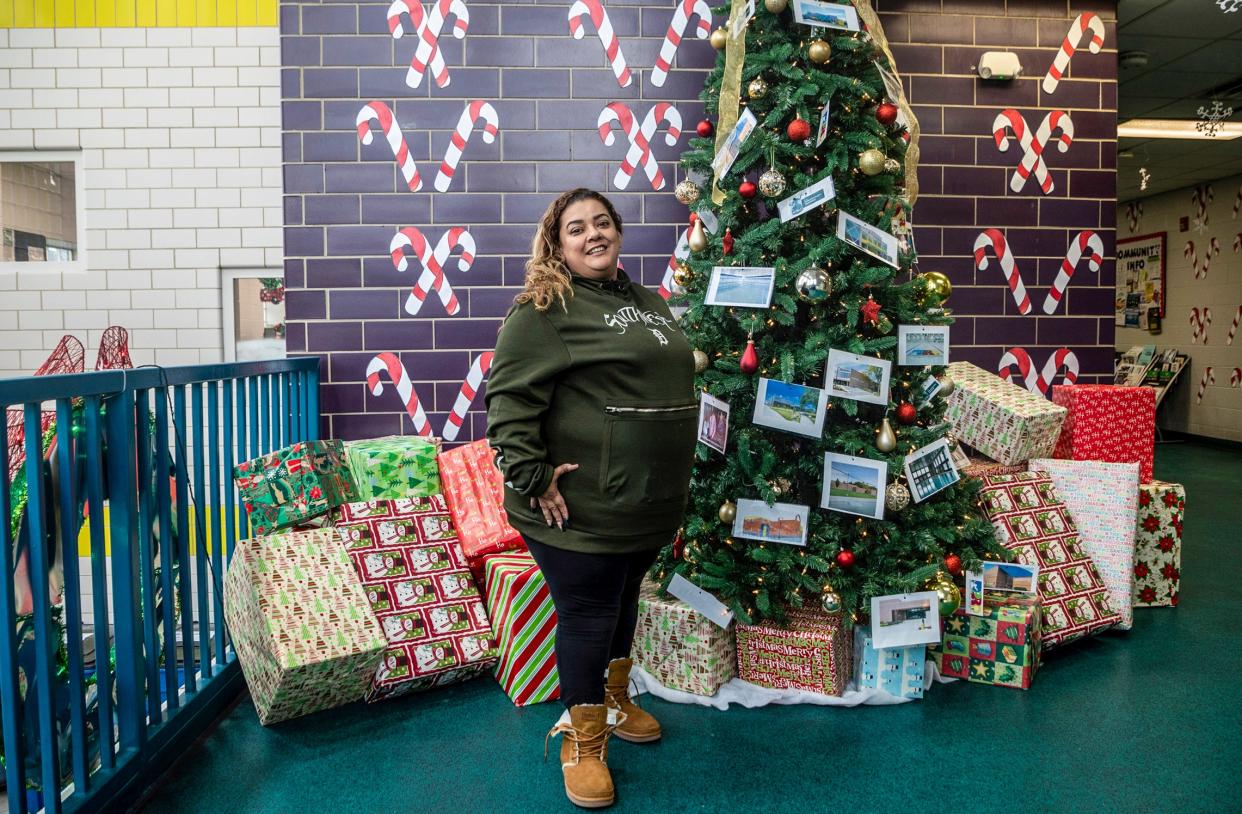 Lisa Gonzalez, a southwest Detroit native, stands next to a Christmas tree at the Patton Recreation Center ahead of the Holiday Festival on behalf of the Congress of Communities and Detroit Champions for Hope in Detroit on Wednesday, Dec. 7, 2022. 