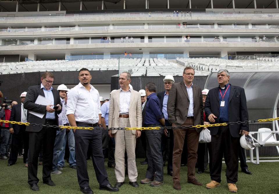 Brazil's former soccer player Ronaldo, second from left, Brazil's Sports Minister Aldo Rebelo, center, FIFA Secretary General Jerome Valcke, second from right, and members of the local World Cup organizing committee inspect the unfinished Itaquerao stadium in Sao Paulo, Brazil, Tuesday, April 22, 2014. The stadium will host the World Cup opener match between Brazil and Croatia in June. (AP Photo/Andre Penner)