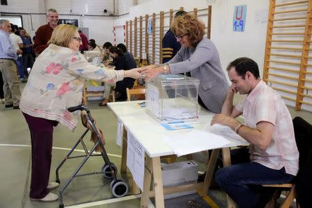 A woman casts her vote during the regional parliamentary elections at a polling station in Vigo, northern Spain, September 25, 2016. REUTERS/Miguel Vidal