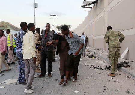 People help a woman injured by a blast near the Mogadishu sea port in Mogadishu, Somalia, May 24, 2017. REUTERS/Feisal Omar