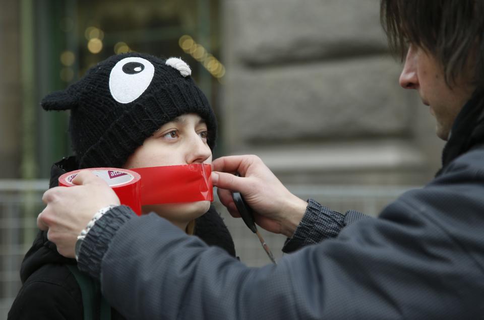 FILE - A gay rights activist bandages the mouth of a fellow activist before a picket to mark the Day of Silence in St. Petersburg, Russia, Friday, April 15, 2016. Russia’s Supreme Court on Thursday, Nov. 30, 2023, effectively outlawed LGBTQ+ activism, in the most drastic step against advocates of gay, lesbian and transgender rights in the increasingly conservative country. (AP Photo, File)