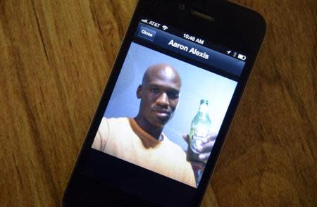 A photo of Aaron Alexis, 34, the suspected shooter who was among 13 people killed in the shooting at Washington Navy Yard, is displayed on the phone of Oui Suthamtewakul owner of the Happy Bowl Asian Restaurant, in White Settlement, Texas September 17, 2013. REUTERS/Tim Sharp