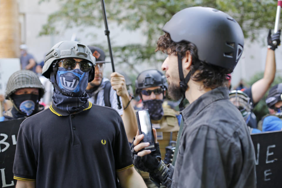 Opposing rallies battle with mace, paint balls and rocks near Justice Center in downtown Portland Saturday, August 22, 2020. Dueling demonstrations in Portland by right-wing and left-wing protesters have turned violent near a county building that's been the site of numerous recent protests. (Brooke Herbert/The Oregonian via AP)/The Oregonian via AP)/The Oregonian via AP)/The Oregonian via AP)