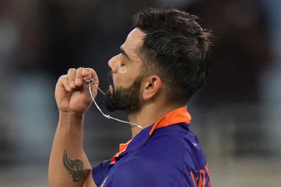India's Virat Kohli holds the locket before kissing it as he celebrates scoring a century during the T20 cricket match of Asia Cup between India and Afghanistan, in Dubai, United Arab Emirates, Thursday, Sept. 8, 2022. (AP Photo/Anjum Naveed)