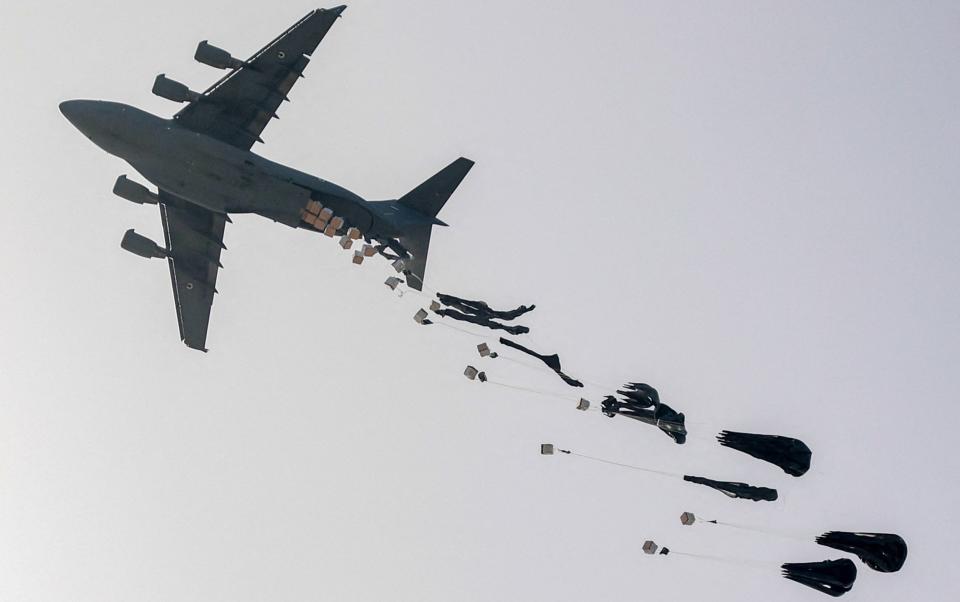 A United Arab Emirates Air Force C-17 Globemaster III military transport aircraft drops aid packages on the northern Gaza Strip