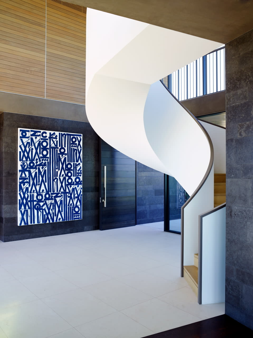 A spiral white staircase with black handrails.