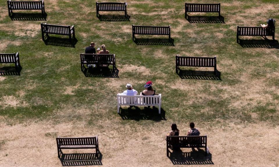 Overhead view of spectators sitting on benches among dry grass