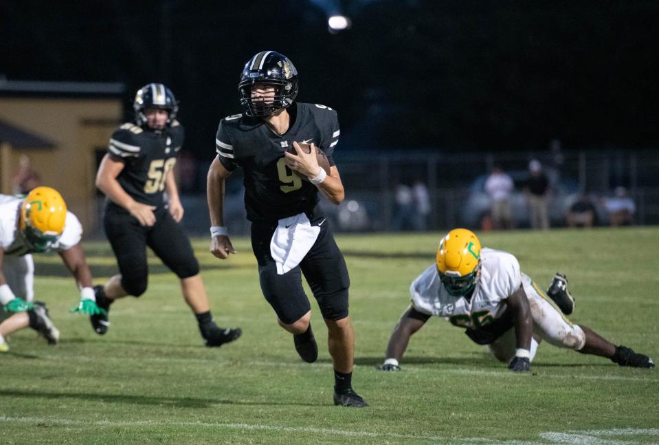 Quarterback Emory Williams (9) keeps the ball during the Pensacola Catholic vs Milton football game at Milton High School on Thursday, Sept. 1, 2022.