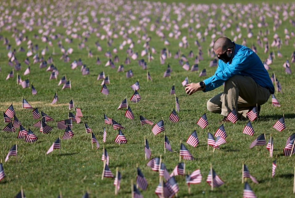 Chris Duncan, whose 75 year old mother Constance died from Covid on her birthday, photographs a Covid Memorial Project installation of 20,000 American flags on the National Mall in Washington, DC (Getty Images)