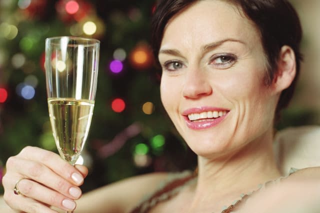 Woman holding glass of wine, smiling, portrait, close-up