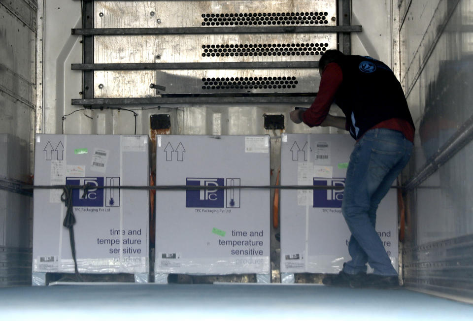 A health worker checks boxes of AstraZeneca COVID-19 vaccines inside a truck, that were delivered to Idlib through a border crossing with Turkey, in Bab Al-Hawa, northwestern Syria, Wednesday, April 21, 2021. Syria's last rebel-held enclave received its first batch of COVID-19 vaccines on Wednesday, with a refrigerated truck offloading over 50,000 of United Nations-secured jabs in the overcrowded province. (AP Photo/Ghaith Alsayed)