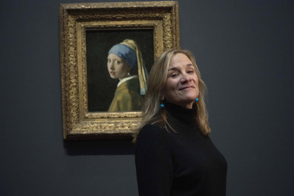 Tracy Chevalier, author of the book Girl With A Pearl Earring, poses in front of the painting Girl With A Pearl Earring during a press preview of the Vermeer exhibit at Amsterdam's Rijksmuseum, Monday, Feb. 6, 2023, which unveils its blockbuster exhibition of 28 paintings by 17th-century Dutch master Johannes Vermeer drawn from galleries around the world. (AP Photo/Peter Dejong)