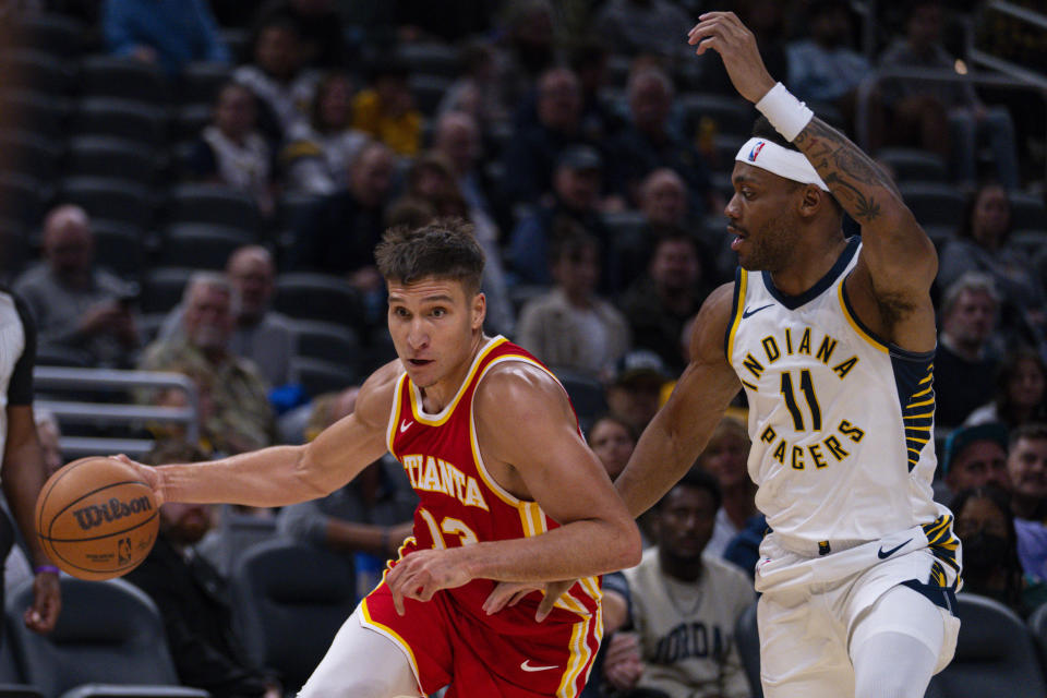 Atlanta Hawks guard Bogdan Bogdanovic (13) drives on Indiana Pacers forward Bruce Brown (11) during the first half of an NBA preseason basketball game in Indianapolis, Monday, Oct. 16, 2023. (AP Photo/Michael Conroy)