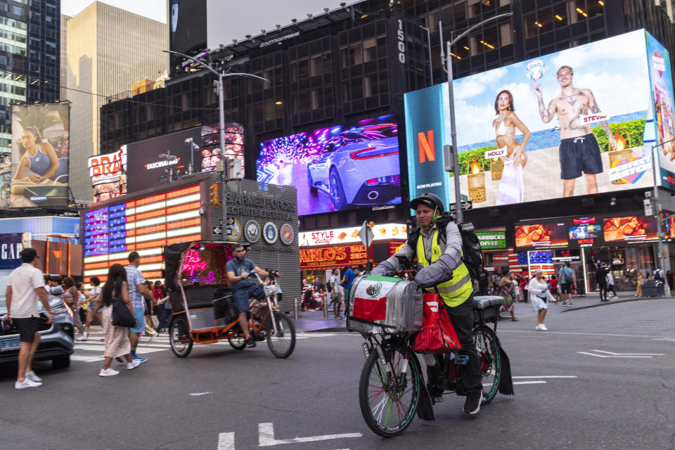 Sergio Solano, un inmigrante de México, pasea en bicicleta por Times Square mientras realiza una entrega, el 21 de junio de 2024, en Nueva York. (Foto AP/Eduardo Muñoz Álvarez)