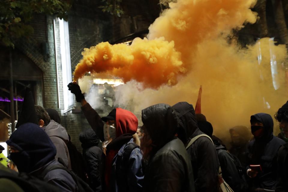 Anti-fascists protesters hold flares during a rally in London, Thursday, Oct. 31, 2019. The EU has allowed Britain to delay its Brexit departure from the bloc until Jan. 31, enabling Britain to hold a general election on Dec. 12. (AP Photo/Matt Dunham)