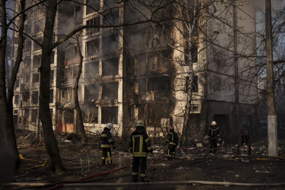 Firefighters work at the scene of an apartment building bombing in Kyiv, Ukraine, Tuesday, March 15, 2022. (AP Photo/Felipe Dana)