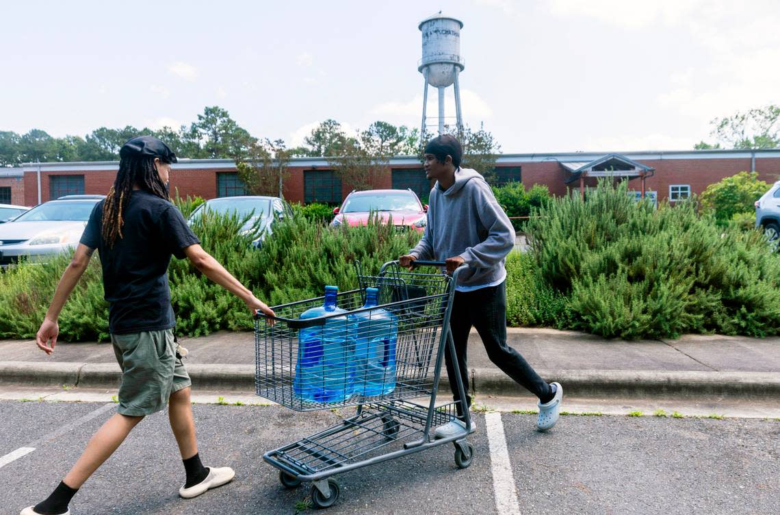 Jada Jinwright, left, Jamari Williams of Pittsboro cart water bottles to their car at Chatham Marketplace in Pittsboro on Tuesday, May 7, 2024.