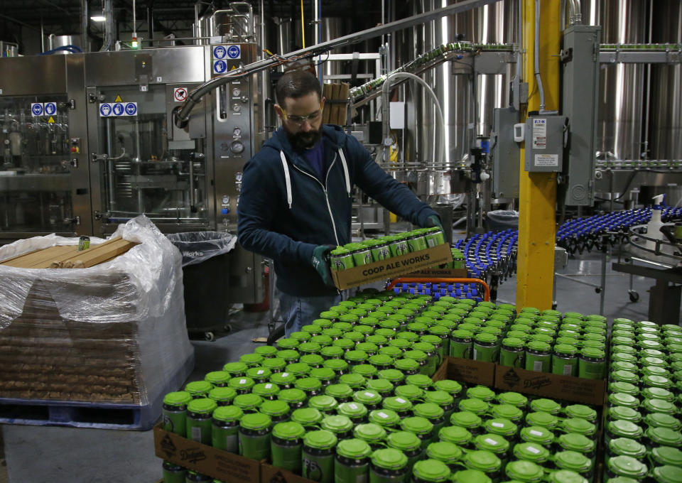 Josh Yager transfers cans of F5, one of their most popular brews, from the production line at COOP Ale Works in Oklahoma City, Friday, Jan. 18, 2019. Rules that went into effect in Oklahoma in October allow grocery, convenience and retail liquor stores to sell chilled beer with an alcohol content of up to 8.99 percent. Previously, grocery and convenience stores could offer only 3.2 percent beer. Liquor stores, where stronger beers were available, were prohibited from selling it cold. (AP Photo/Sue Ogrocki)