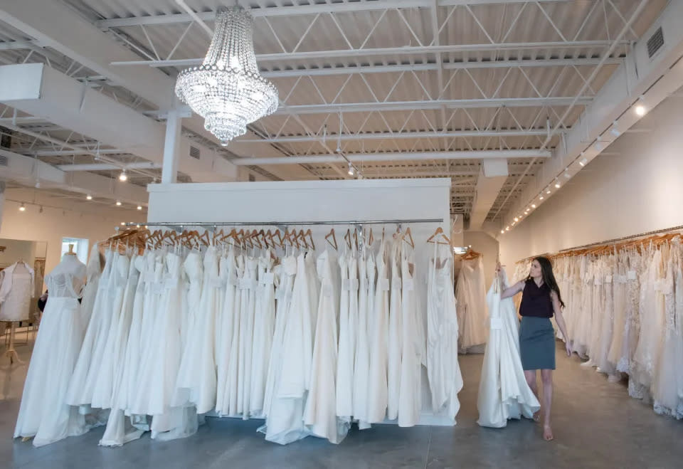 La estilista de novias Lauren Brady devolviendo un vestido a un perchero en Bliss Bridal en Fairhope, Alabama, el jueves 20 de junio de 2024.