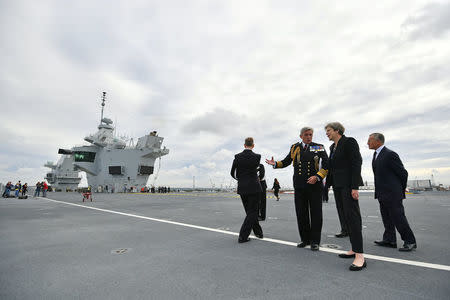 Britain's Prime Minister Theresa May talks with First Sea Lord Admiral Philip Jones on the British aircraft carrier HMS Queen Elizabeth, during her tour of the ship, after it arrived at Portsmouth Naval base, its new home port, in Portsmouth, Britain August 16, 2017. REUTERS/Ben Stansall