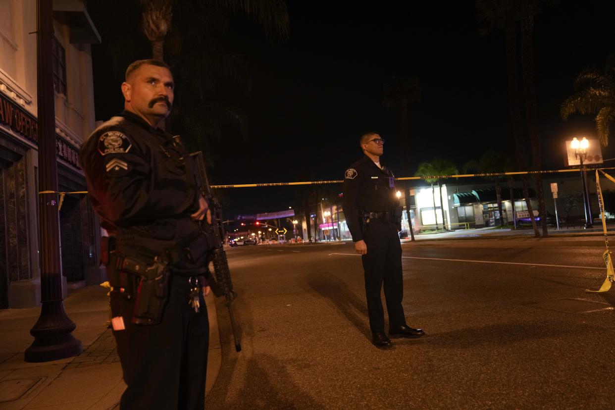 Two police officers stand guard near a scene where a shooting took place in Monterey Park, Calif., Sunday, Jan. 22, 2023. Dozens of police officers responded to reports of a shooting that occurred after a large Lunar New Year celebration had ended in a community east of Los Angeles late Saturday. (AP Photo/Jae C. Hong)