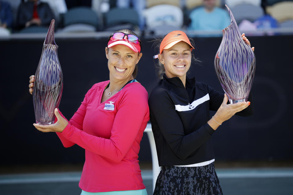 Andreja Klepac, left, and Magda Linette hold up their trophies after winning the doubles title against Lucie Hradecka and Sania Mirza in finals action at the Charleston Open tennis tournament in Charleston, S.C., Sunday, April 10, 2022. (AP Photo/Mic Smith)