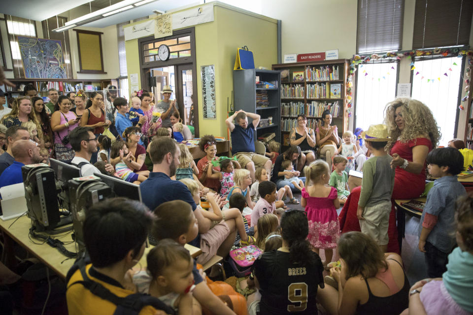 Vanessa Carr , right, reads to children during Drag Queen Story Time at the Alvar Library in New Orleans on Saturday, Aug. 25, 2018. Children and parents and caregivers packed into the library to hear drag queens Blazen Haven and Carr read stories and sing songs during the event. (Scott Threlkeld/The Advocate via AP)