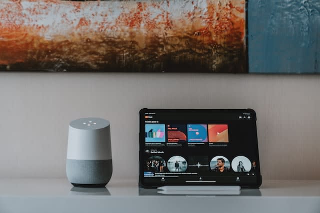 YouTube music on a laptop and a google home on a table