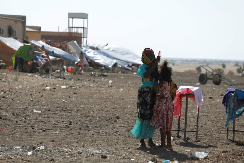 Ethiopian refugee brushes a girl's hair the Hamdeyat refugee transit camp