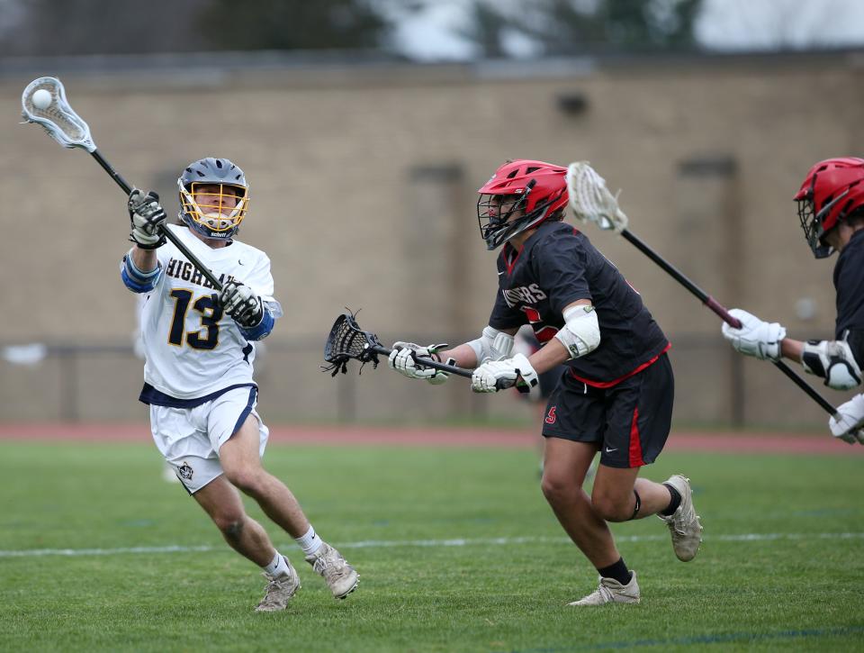 Highland's Logan Zehr looks to make a pass while being covered by Red Hook's Gabe Gravino during an April 21, 2022 boys lacrosse game.