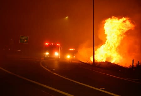 Firefighters arrive to help fight a wind-driven wildfire in Sylmar, California